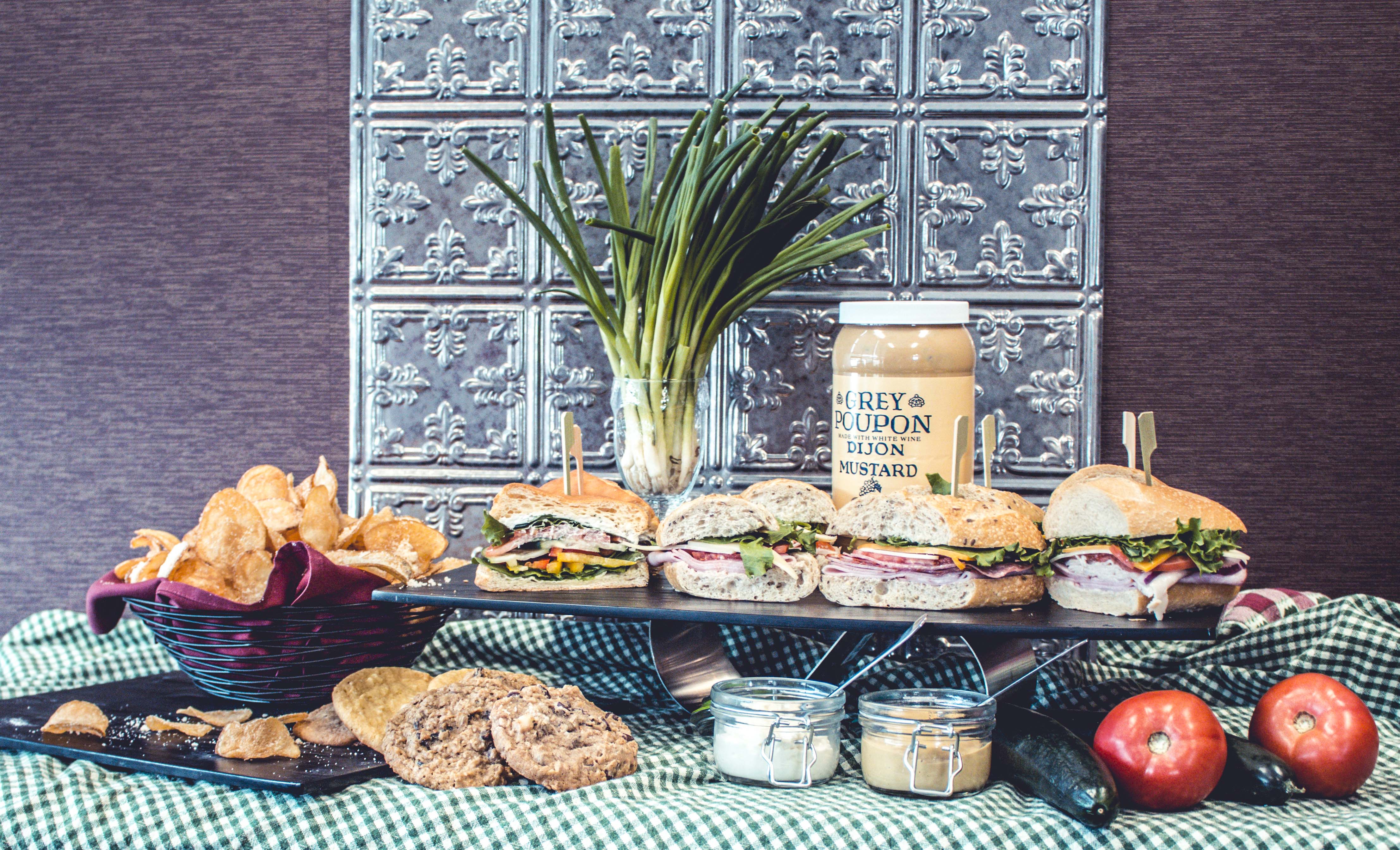 Lunch display that includes fresh-made sandwiches, chips, and baked cookies